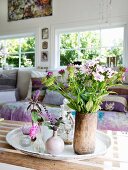 Garden flowers in various vases on tray