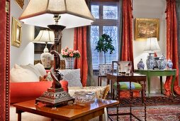 Seating area with lamps, valuable vases on antique side tables, mixture of patterns on traditional fabrics and Oriental rugs