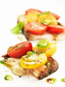 Bruschetta topped with red and yellow tomatoes