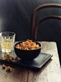 A bowl of spiced popcorn next to a glass of white wine