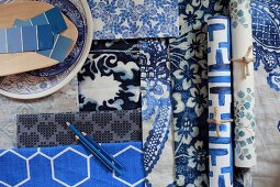 Wallpapers and fabrics in blue and white patterns and paint sample strips