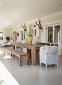 Wooden table in seating area and loungers on furnished terrace