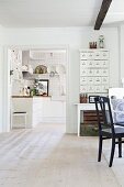 Blick von Esszimmer durch breiten Durchgang in Küche auf weiße Unterschränke