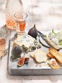A cheese platter with figs, grilled bread and rose wine