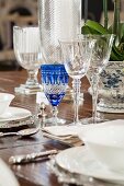 Detail of table set with crystal glasses, white crockery and silver cutlery
