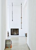 Climbing ropes hung from ceiling in front of fireplace integrated in wall of modern interior