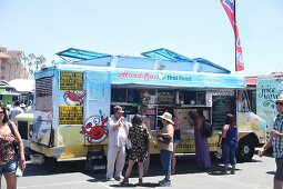 Customers in front of a Thai food truck at a food truck festival in California, USA
