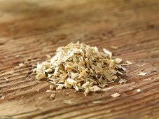 A pile of oat straw on a wooden surface
