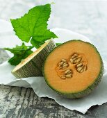 Galia melon, halved, with leaves