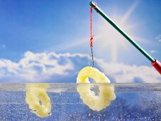 Battered squid rings being dipped into liquid