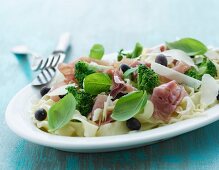 Pasta salad with raw ham, broccoli, Parmesan and basil