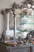 Antikes Buffet mit verziertem Spiegelaufsatz, davor angerichtete Speisen