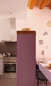 Counter with pastel lilac body between kitchen and dining areas