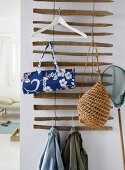 Bags, jackets and a hanger on a homemade coat rack made from driftwood