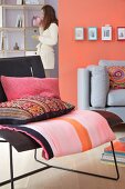 Wohnraum mit gedeckter Sitzmöblierung in Schwarz und Grau, ergänzt durch Mustermix im Farbenspiel mit Rosa und Koralle