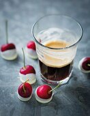 An espresso and cherries with white chocolate