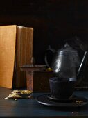 A cup of tea with a teapot on a wooden table