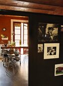 View past souvenir photos on black partition to metal bar stools at breakfast bar in kitchen