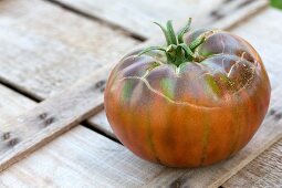 A red tomato on a wooden crate