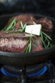 Steak with rosemary and butter in a frying pan