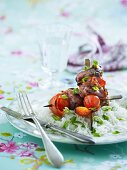 Mit Pesto mariniertes Schweinefleisch im Serranomantel mit Tomaten und Paprika am Spiess, dazu Reis mit Frühlingszwiebeln