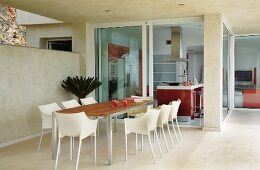 Dining set with plastic shell chairs on terrace of modern holiday home