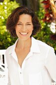 A brunette woman wearing a white blouse