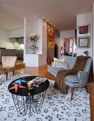 Filigraner Couchtisch und schwarz- weiss gemusterter Couch im Fiftiesstil in offenem Wohnraum