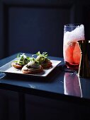 Toasts mit Jakobsmuschel-Tatar und Seeigelsauce und Ruby Crush Cocktail