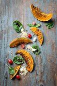 Grilled pumpkin wedges with a bulgur and spinach salad and feta cheese and wooden surface