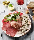 Italienischer Vorspeisenteller mit Parmaschinken, Carpaccio, Vitello tonnato, Salami, Rucola und Parmesan