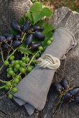 Linen napkin tied with jute cord in a figure-of-eight knot next to freshly picked grapes