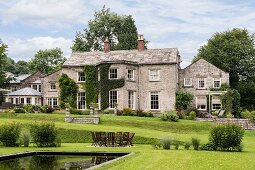 Ein englisches Herrenhaus aus Stein mit parkähnlichem Garten