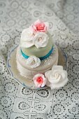 A cake decorated with fondant icing and sugar roses