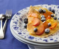 Süsses Omelett mit Blaubeeren, Pfirsichen und Puderzucker