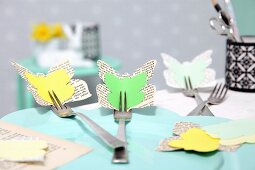 Osterdeko in Gelb-Grün: Schmetterlinge aus Papier an Gabeln befestigt