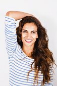 Young, brunette woman wearing white and blue striped top