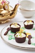 Pistachio mousse in chocolate bowls with chocolate spoons