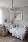 Old metal bed, fan on bedside cabinet, retro pendant lamp and old floorboards with natural patina in teenager's bedroom