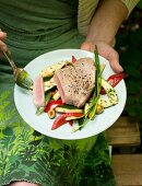 A woman eating tuna fish salad in a garden