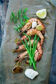Prawns with garlic, asparagus and mayonnaise on a piece of baking paper