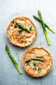 Two asparagus and smoked salmon tartlets with asparagus spears (seen from above)