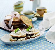 Biscuit sandwiches with cream, blueberries and icing sugar