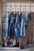 Jeans hanging from wall hooks in rustic interior