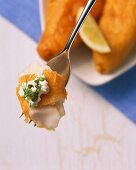 Battered fish with remoulade on a fork