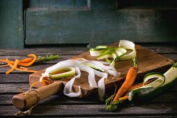 Gehobelte Gemüsebandnudeln von Möhre, Rettich und Zucchini auf Küchenbrett