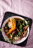 A rice dish with vegetables, mushrooms and meat