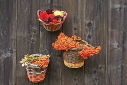 Baskets filled with berries and flowers hung on wooden wall