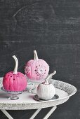 Ornamental squashes painted pink and white decorating table