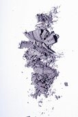 Purple eye shadow crumbled onto a white surface